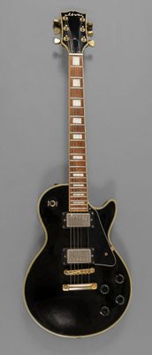 une image représentant une guitare électrique noire sur fond gris
