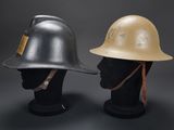 pair of helmets on mannequin heads against a gray background
