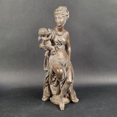 statue of a woman holding a bouquet of flowers on a black surface