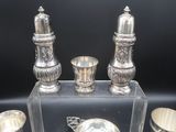 un plateau en argent et des couverts en argent exposés sur un fond noir