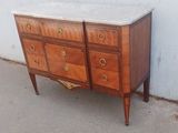 une commode au plateau en marbre posée sur le trottoir