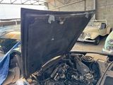 a car that has a hood open in a garage