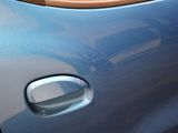 a close up of a door handle on a blue car