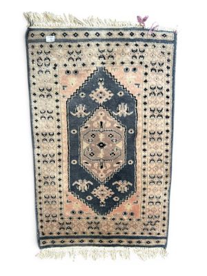 un tapis noir et beige orné d'un motif en médaillon