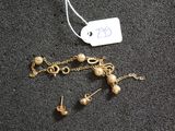 un collier et une boucle d'oreille posés sur une table, avec une étiquette de prix