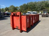 une benne à ordures rouge posée au milieu d'un parking