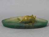 a statue of a mouse that is sitting on top of a green plate