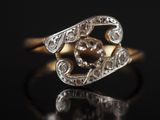 gros plan d'une bague en or et diamants sur une surface noire