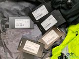 four tags that are attached to a jacket on a bed