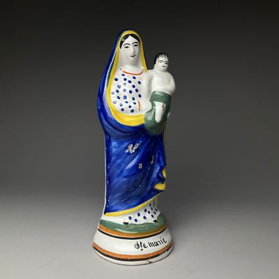 figurine d'une femme tenant un bébé dans ses bras