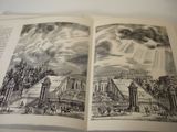 an open book with a drawing of a city on it
