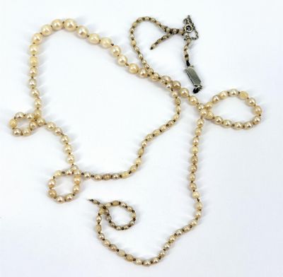 gros plan d'un collier de perles sur une surface blanche