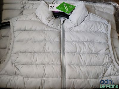 a white vest with a green tag on it