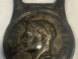 a close up of a bottle opener with a coin on it