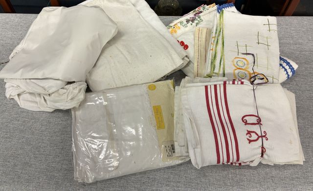 Une caisse de linge de table et torchons, alèses et cache sommier