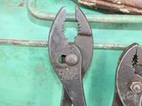 two pliers and a wrenet on a table