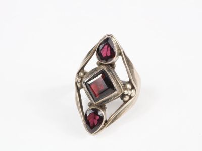 un gros plan d'une bague en argent sertie de grenats
