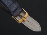 a close up of a watch strap with a gold buckle
