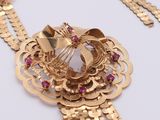 a close up of a gold necklace on a white surface