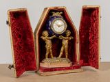 une horloge posée dans un boîtier sur une table