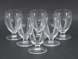 six verres à vin vides posés sur une surface noire