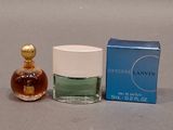 a small bottle of perfume next to a box of perfume