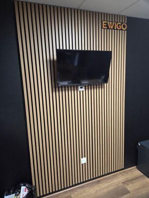 une télévision fixée au mur dans un coin de la pièce