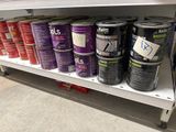 many cans of paint sitting on a shelf in a store