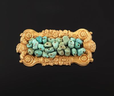 a close up of a gold and turquoise beaded broochle