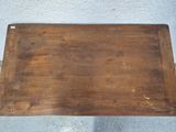 an old wooden tray with a handle on a table