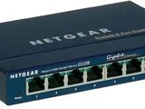 un gros plan d'un commutateur sur fond blanc, avec l'inscription « Netgear »