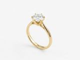 a yellow gold engagement ring with a round diamond