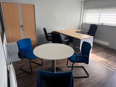 une pièce dans laquelle se trouvent une table, des chaises et un bureau