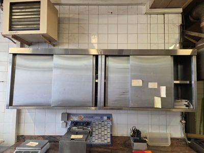 a kitchen with stainless steel cabinets and a wooden counter