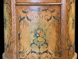 une petite armoire en bois ornée d'un motif floral