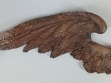 a close up of a wooden sculpture of a bird with wings