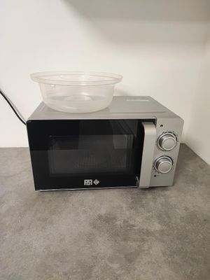 a microwave with a bowl on top of it