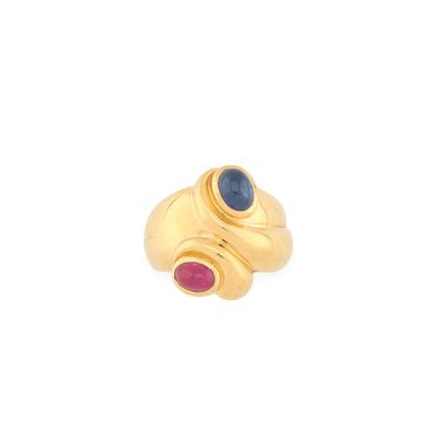 un gros plan d'une bague en or sertie d'une pierre bleue et rouge