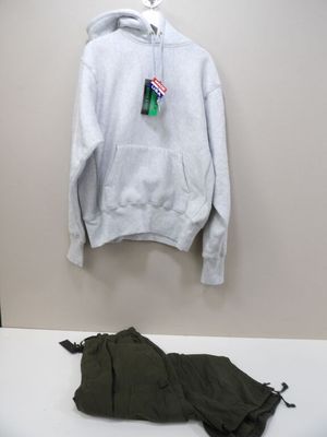 a white hoodie hanging on a wall next to a pair of pants