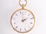 a gold pocket watch with roman numerals on the face