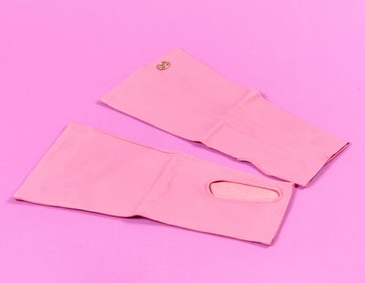 une paire de gants roses sur un fond rose