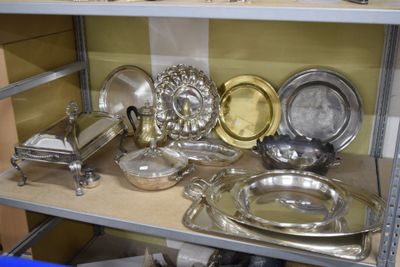 une étagère sur laquelle sont disposés de nombreux plats en argent