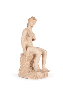 l'image d'une statue de femme assise sur un rocher