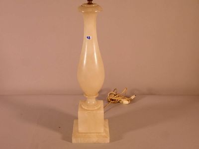 une lampe posée sur une table à côté d'un mur