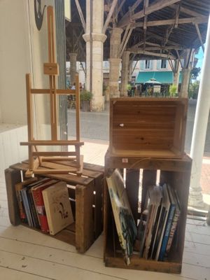 deux caisses en bois, sur lesquelles sont posés des livres, sous un porche