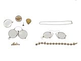 une photo représentant un ensemble d'objets, notamment des lunettes, des bracelets et des broches