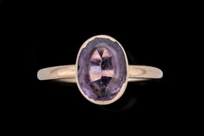 Gros plan sur une bague contenant une pierre violette