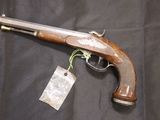 a gun with a tag on it sitting on a black cloth