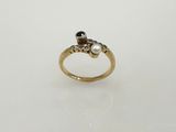 un gros plan d'une bague en or sertie de deux diamants noirs et blancs
