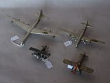 three small model airplanes are sitting on a white surface